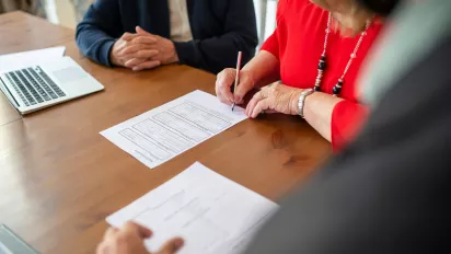 A person signing a document.