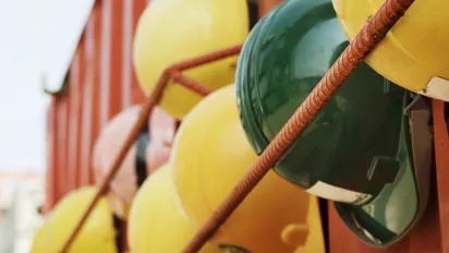 Multiple hard hats suspended on a wall.