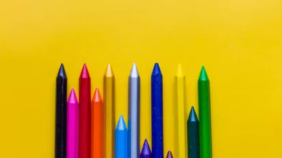 An set of crayons set against a yellow background.