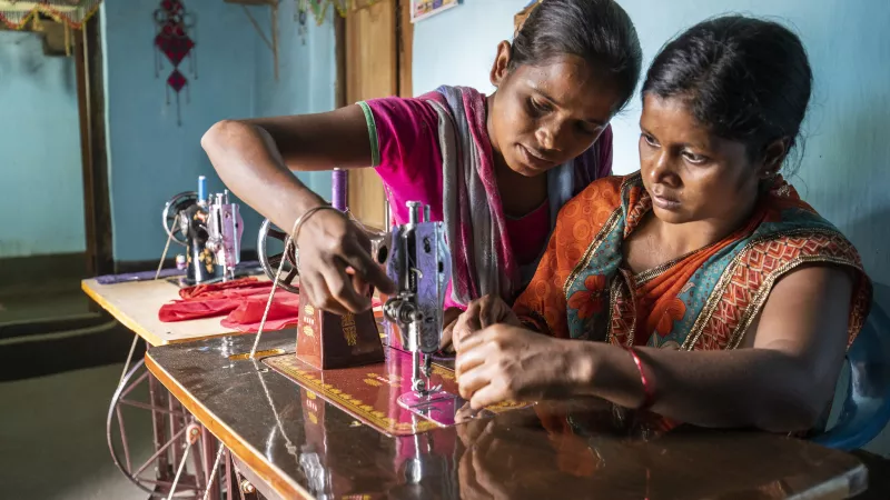 Two women working with a sewing machine