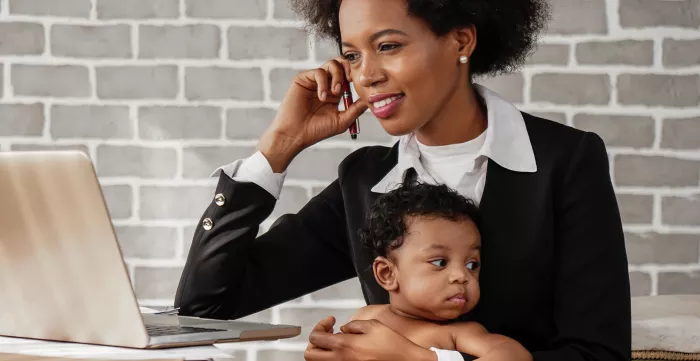 An african american business woman with baby working at home