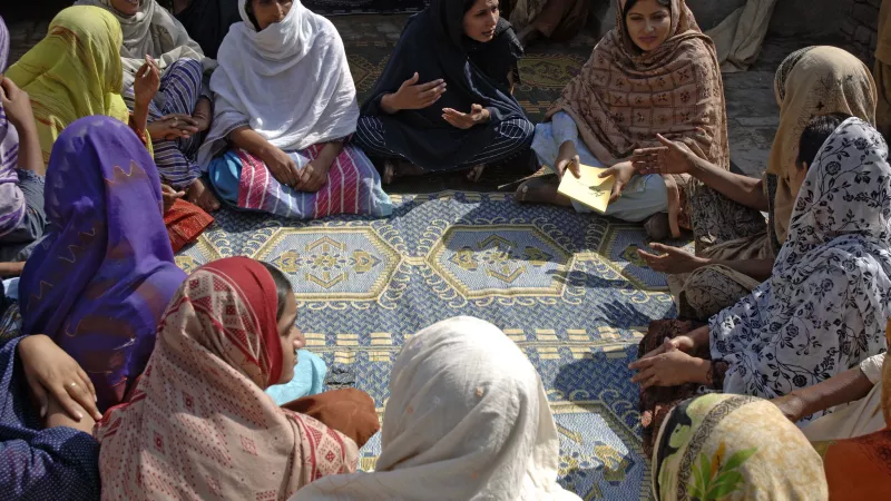 A group of women sit on the floor and discuss